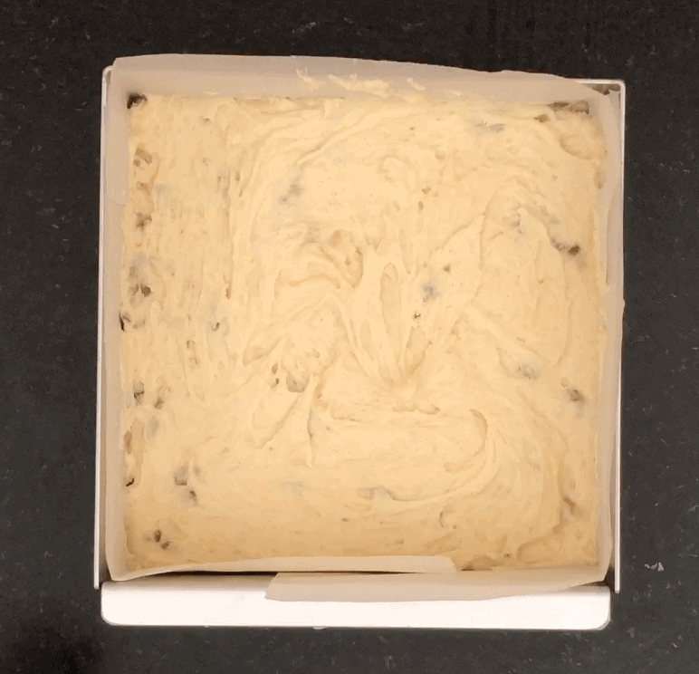 Square cake tin filled with walnut cake batter