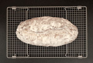 Loaf of stollen on a cooling rack dusted with icing sugar