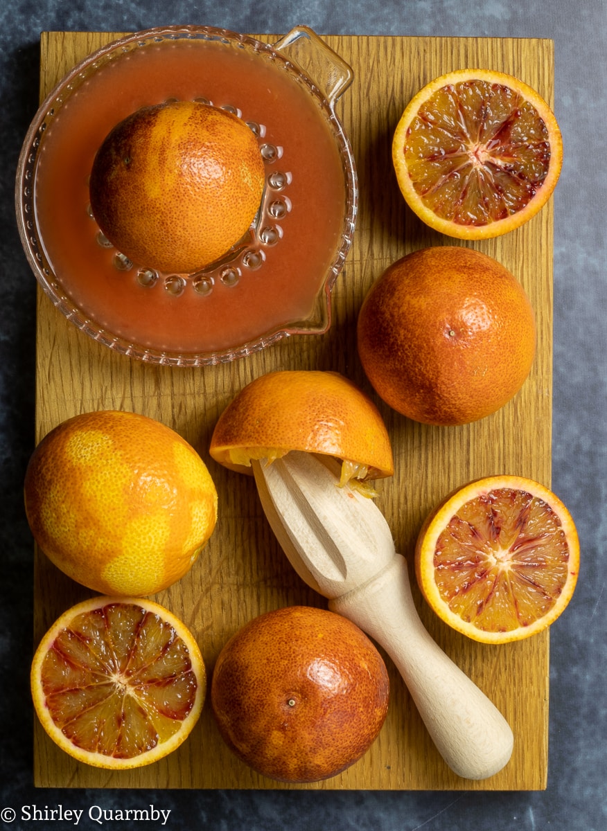 Cut oranges being squeezed