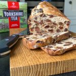 Sliced fruit loaf on a board with a knife